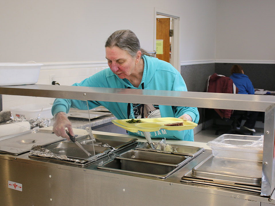 a person putting food on a plate